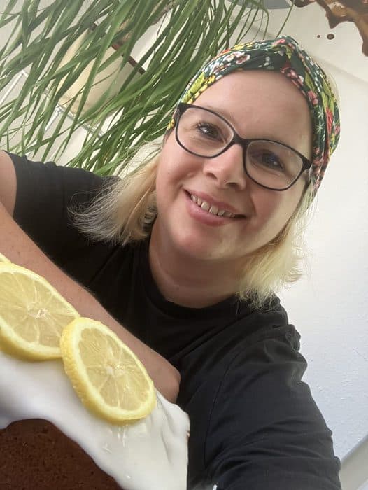 Alwina Simon lächelt mit selbstgebackenem Zitronenkuchen mit Zitronenscheiben, Sinnbild für Zitronenkuchen statt Vodka Lemon und bewusste Entscheidungen.