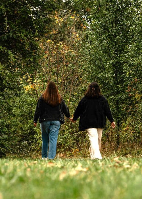 Zwei Menschen gehen schweigend nebeneinander durch die Natur und erleben, wie sie gemeinsam schweigen und sich nah sind