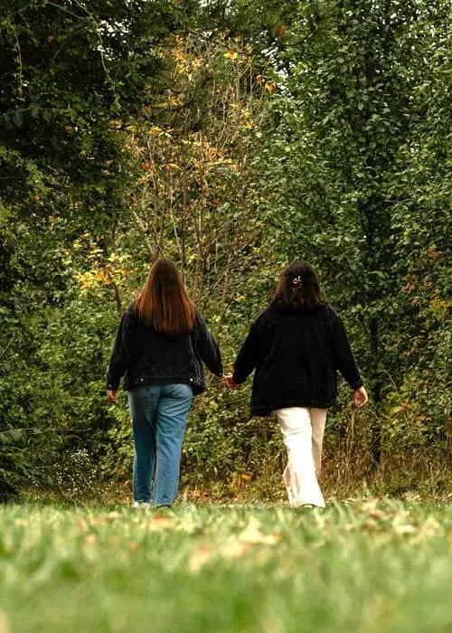 Zwei Menschen gehen schweigend nebeneinander durch die Natur und erleben, wie sie gemeinsam schweigen und sich nah sind