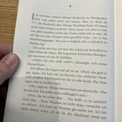 Aufgeschlagene Buchseite aus „The Big Five for Life“ von John Strelecky, Kapitel 4, Seite 16, mit einer Szene an Bord einer Boeing 777.