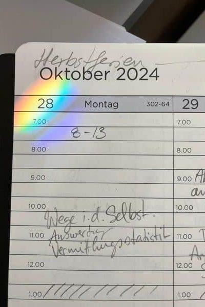 Kalenderseite vom Montag, 28. Oktober 2024, mit einer Regenbogenreflexion über der Zahl 28.
