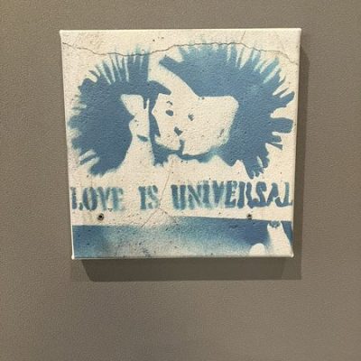 Stencil-Graffiti auf Leinwand mit zwei sich küssenden Punks und dem Schriftzug „Love is universal“.